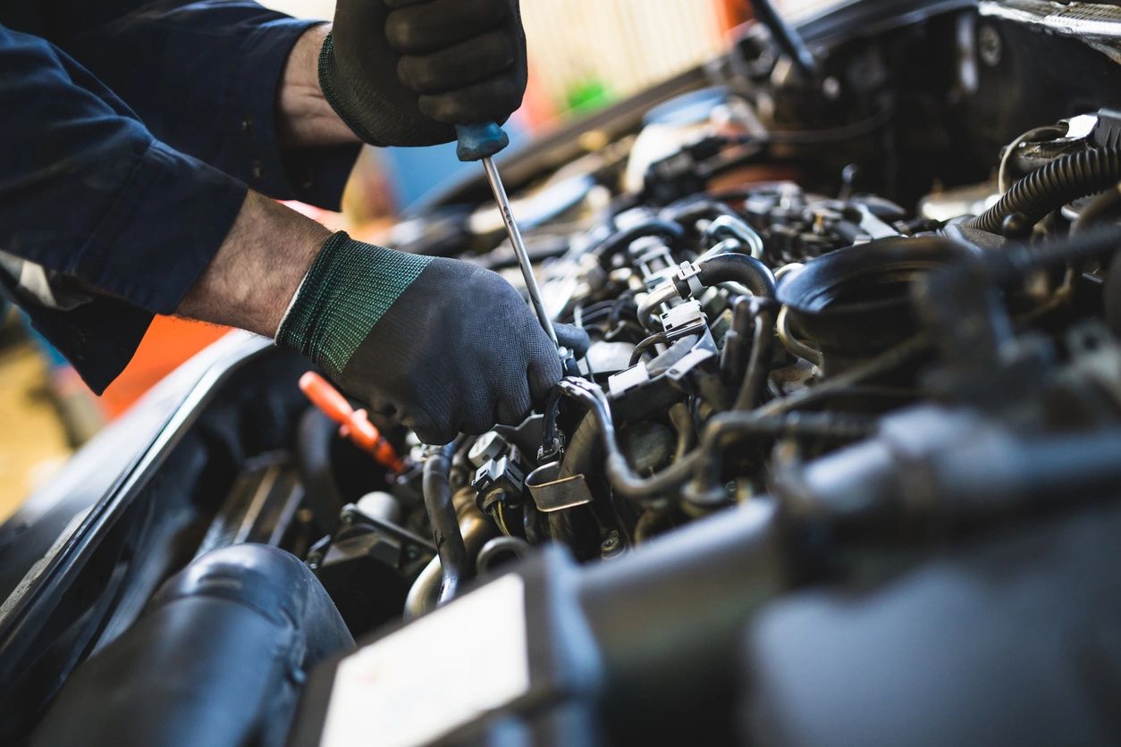 A person working on an engine in the process of repairing it.